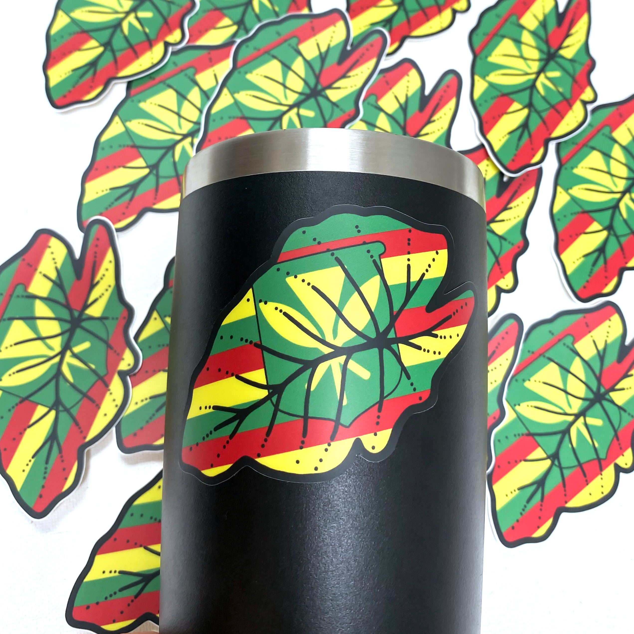 A black cup featuring a decorative leaf design, showcasing a blend of elegance and nature-inspired aesthetics