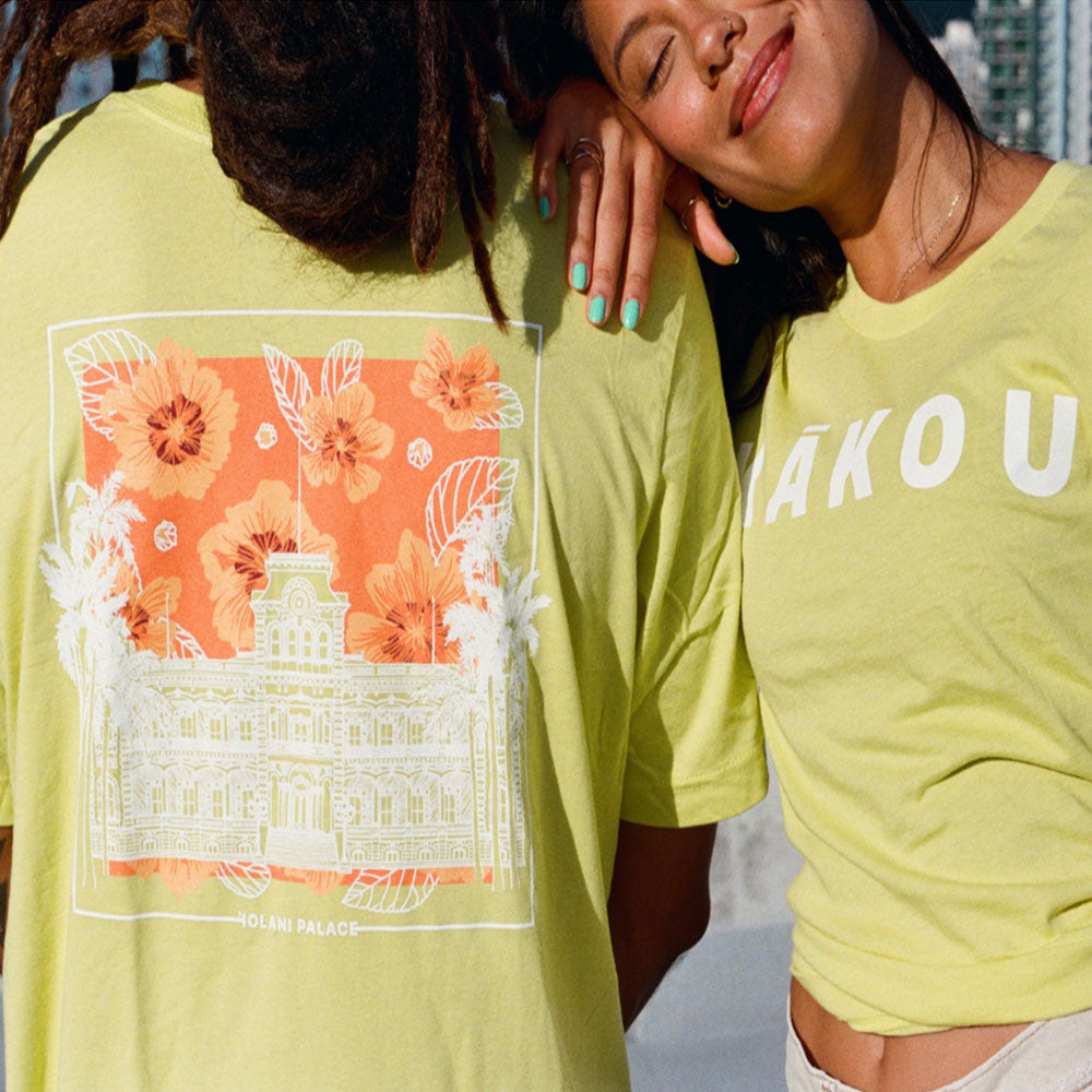 Two individuals wearing matching shirts that read "Tiki Bar," smiling and posing together.