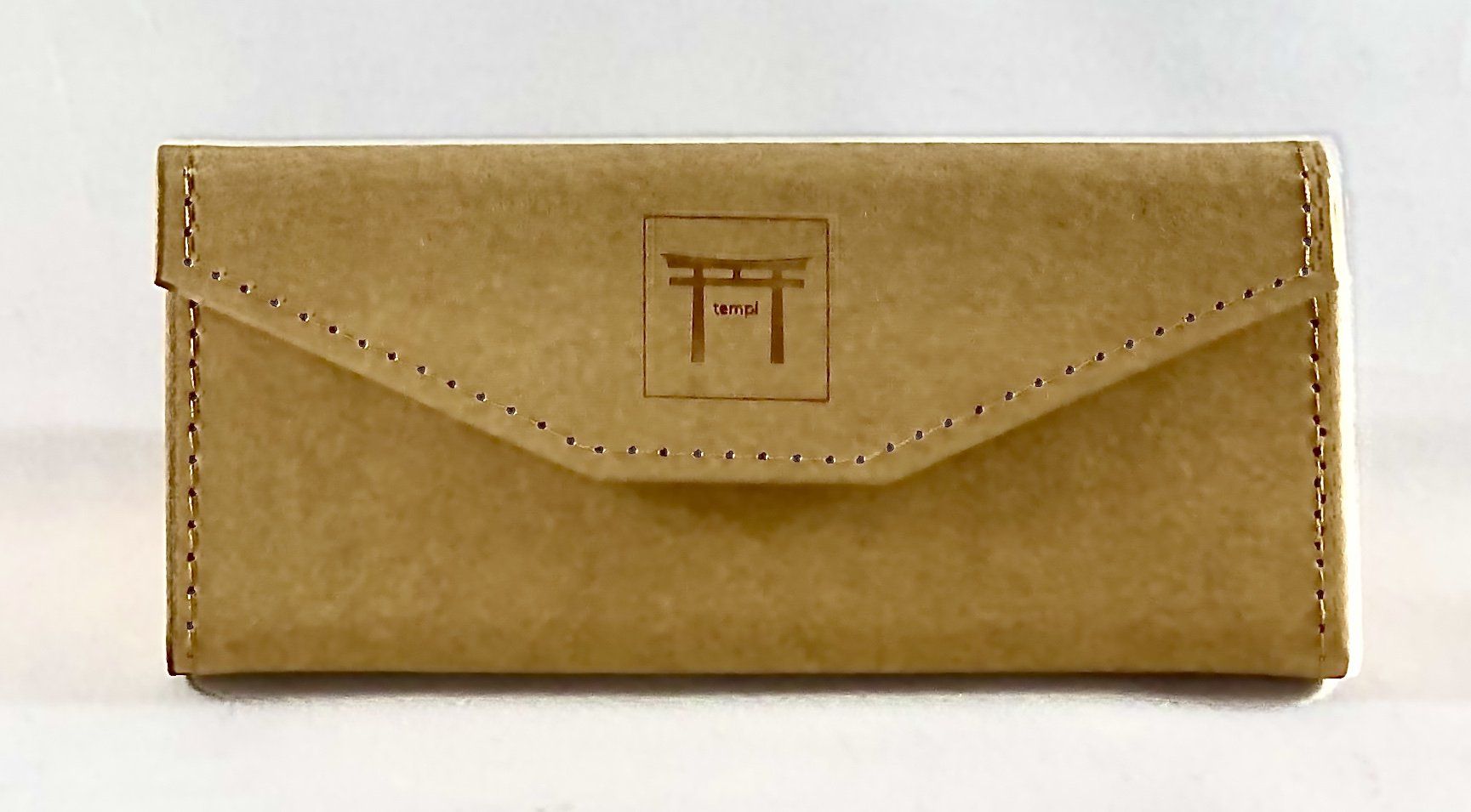 Eco-friendly Templ sunglasses case in textured tan material, stitched with precision and embossed with the signature Torii gate logo, designed for minimalist style and mindful packaging.