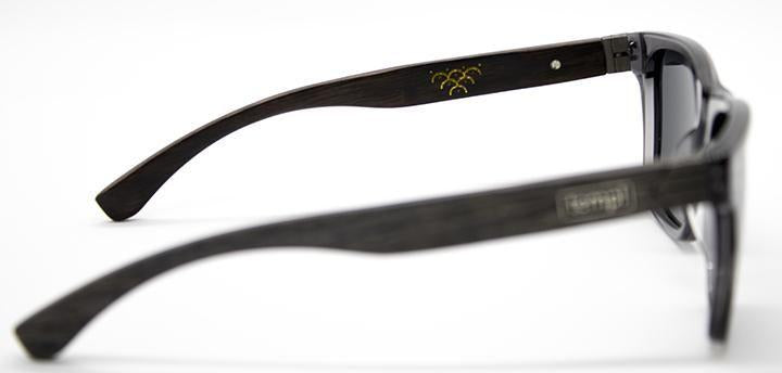 Templ sunglasses shown from a side angle, featuring dark wood-textured arms with engraved gold emblem, blending artisanal detail and everyday durability in a sleek, modern silhouette.