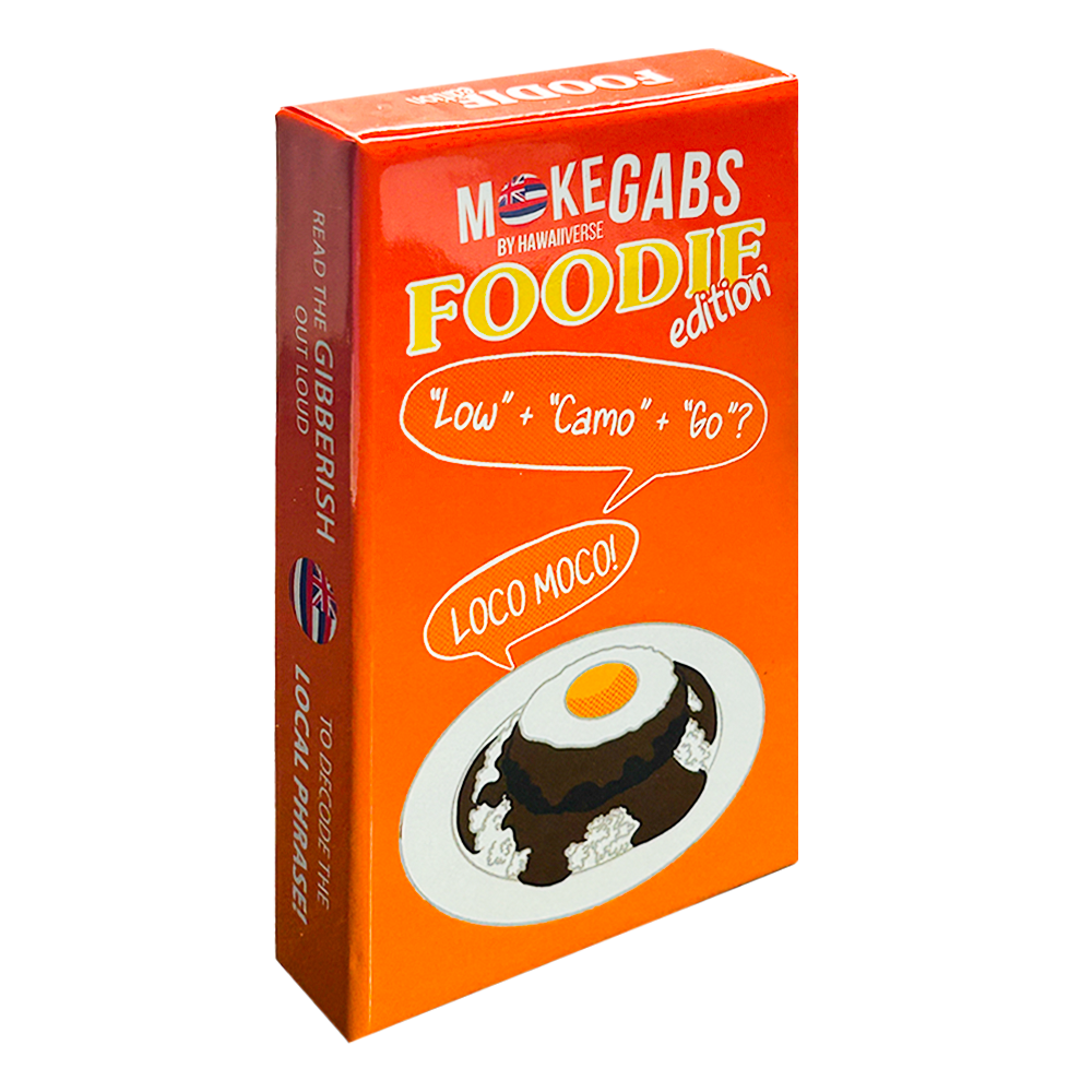 An orange rectangular product box for 'M-Kegabs by Hannah Reese Foodie edition' featuring a cartoon illustration of a chocolate cake with a fried egg on a plate and speech bubbles reading 'Low' + 'Cam' + 'Go'? and 'LOCO MOCA!'.