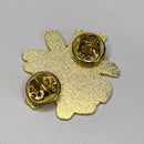 Gold-colored flower-shaped pin on a gray background