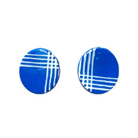 A pair of navy blue palaka print clay oval stud earrings with gold plated earring posts and silicone earring backs.